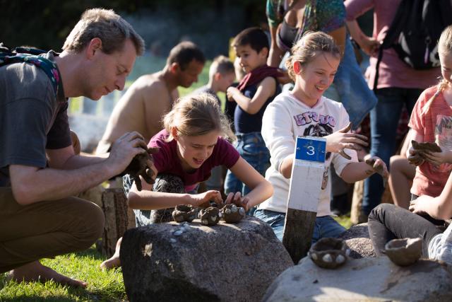 Kinderen actief met klei aan het werk om archeologische vondsten na te maken