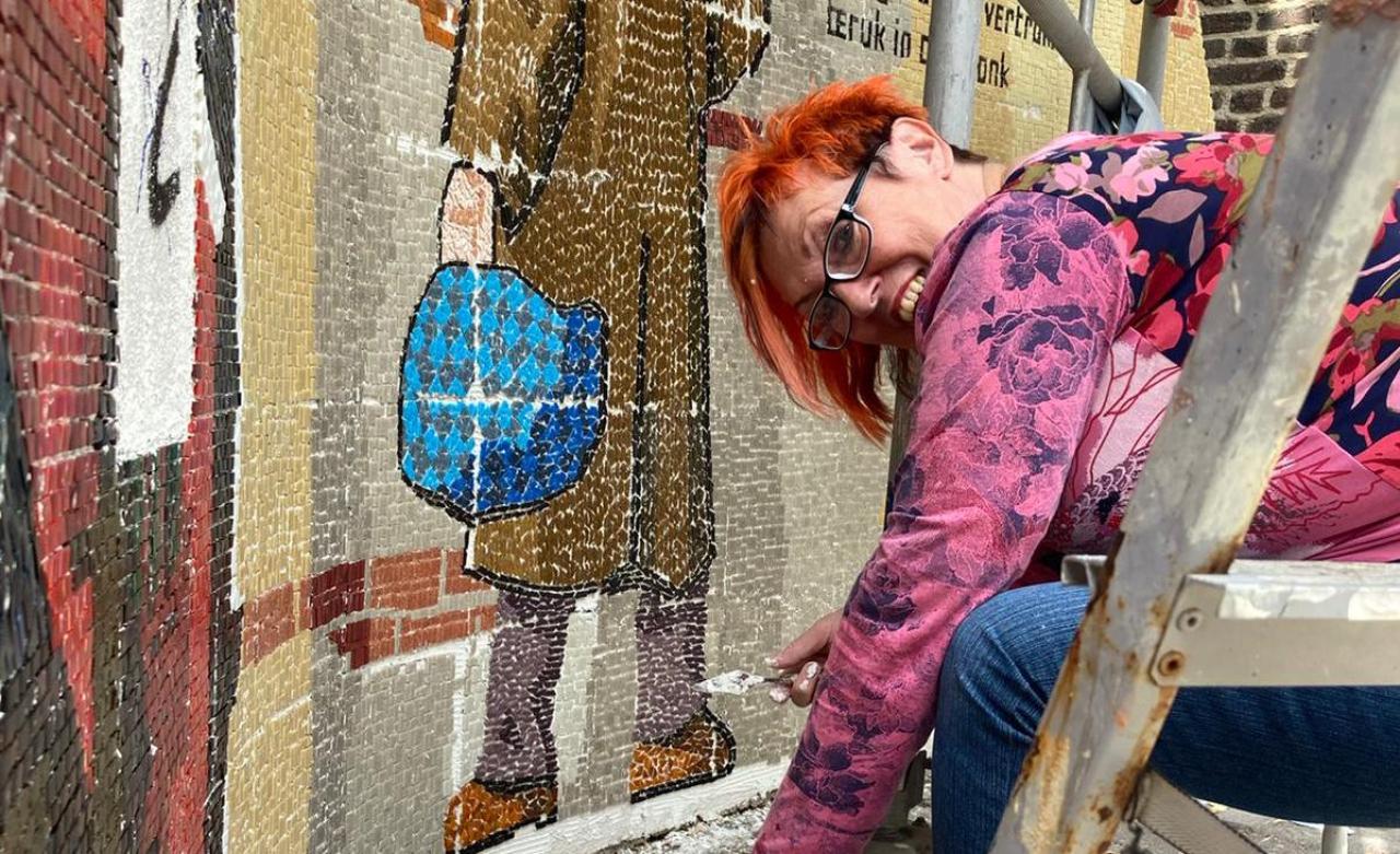 Een wijkbewoner werkt aan een mozaïek over het mijnverleden